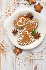 Christmas gingerbread  cookies in the shape of hearts and stars on a white wooden table