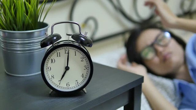 alarm clock with woman on the bed