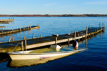 Naklejka premium Sunken motorboat moored at a wooden pier and abandoned. Sea is motionless and calm.