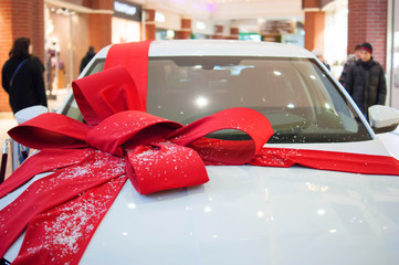 The white car with red bow