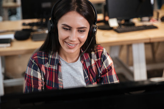 Girl sitting by the computer in headphone