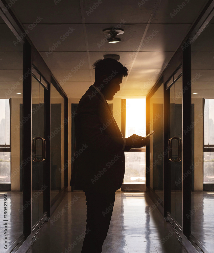 Wall mural silhouette of businessman use phone chatting alone in front of c