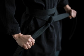 Confident karate player holding his belt