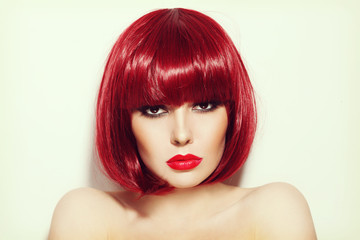 Vintage style portrait of young beautiful sexy red-haired girl with bob haircut and stylish make-up