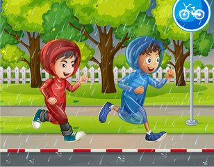 Two boys in raincoat running on pavement