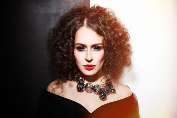 Vintage style portrait of young beautiful woman with gothic Halloween make-up and black scleral lenses