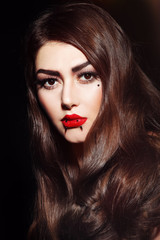 Fototapeta premium Portrait of young beautiful woman with stylish red lips make-up and facial piercings