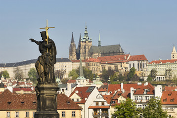 Baroque Statues on the Charles Bridge with beautiful Prague Castle and St. Vitus Cathedral background. Focused to Prague Castle