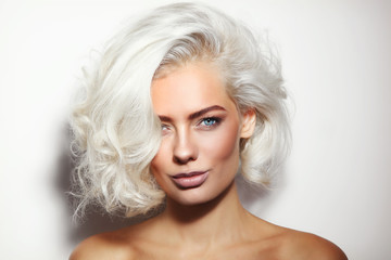 Portrait of young beautiful tanned platinum blonde woman with clean make-up