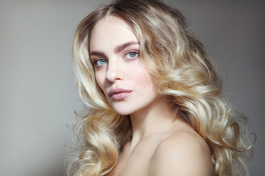 Portrait of young beautiful healthy woman with natural clean make-up and blonde curly hair
