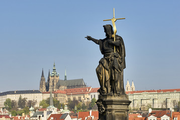 Baroque Statues on the Charles Bridge with beautiful Prague Castle and St. Vitus Cathedral background. Focused to Prague Castle