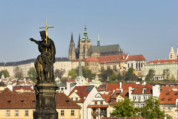 Obraz premium Baroque Statues on the Charles Bridge with beautiful Prague Castle and St. Vitus Cathedral background. Focused to Prague Castle