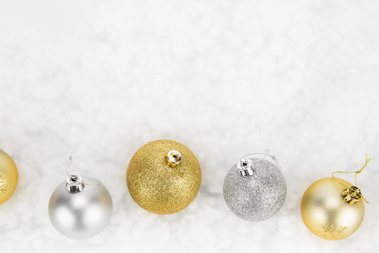 Gold And Silver Christmas Baubles Isolated Against White