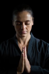 Fototapeta na wymiar Female karate player in prayer pose