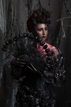 Dark queen in black fantasy costume on dark gothic background
