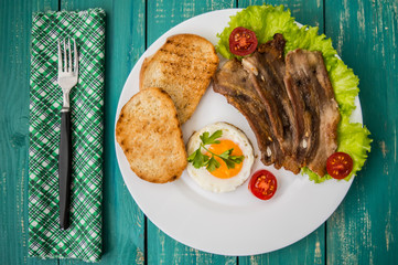 English breakfast - fried egg, tomatoes, bacon and toast. Top view