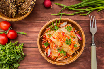 Cabbage rolls in tomato sauce in a bowl. wood background. Top view