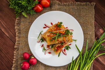 Cabbage rolls in tomato sauce. white plate. wood background. Top view