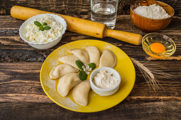 Boiled dumplings with cheese for breakfast. Wooden table. Top view
