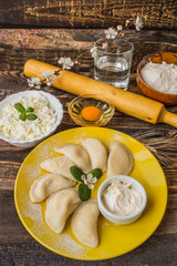 Boiled dumplings with cheese for breakfast. Wooden table. Top view