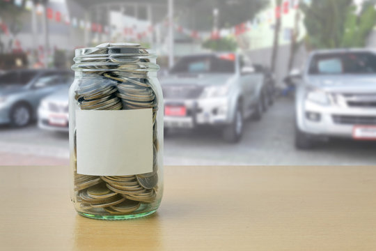 money in the glass bottle with Car showroom background blur