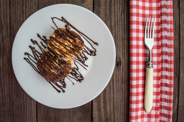 Cheesecakes covered with chocolate on a wooden background. Top view