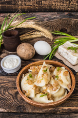 Boiled dumplings with potatoes. Wooden background. Top view