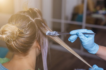 Professional hairdresser dyeing hair of her client in salon. Selective focus. - 130531675