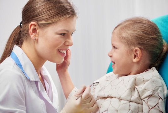 Smiling female dentist with little patient in dental clinic. Concept of yearly teeth examination.  