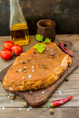 Marinated steak with spices on a wooden table