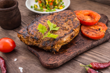 Grilled steak with spices on a wooden board. Country Buffet. Top view
