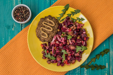 Salad Vinaigrette of beets and steak on a turquoise wooden background