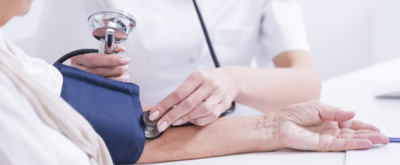 Doctor measuring patient's blood presure