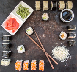 Sushi Set sashimi and  rolls on a dark board. Wooden background. Top view