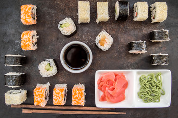 Sushi Set sashimi and rolls on a dark board. Wooden background. Top view