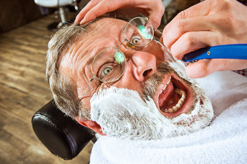 The senior man visiting hairstylist in barber shop.