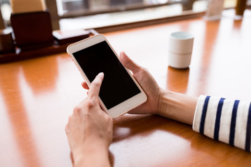 Woman using cellphone at restaurant