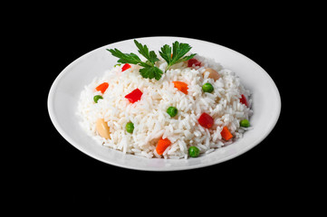 rise risotto with vegetables on white plate isolated on black 
