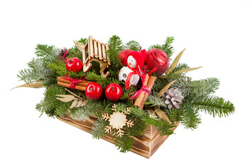 Christmas arrangement of fir branches, in wooden box, snowman with sled. White background.