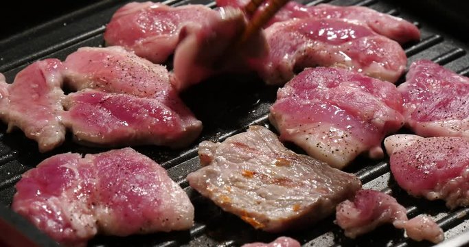 Cooking Frying pork belly turn with chopsticks.