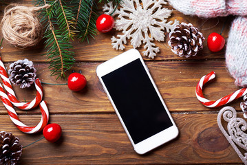Smart phone mock up with rustic Christmas decorations for app presentation. View from above