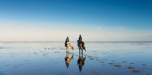 deux cavalières se promenant sur la plage