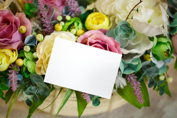 flowers in basket on the light wooden background. Space for text.
