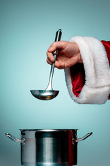 The Santa hand holding a ladle or kitchen spoon