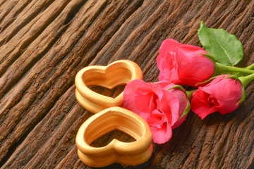 The wood hearts and three pink rose on bark. 