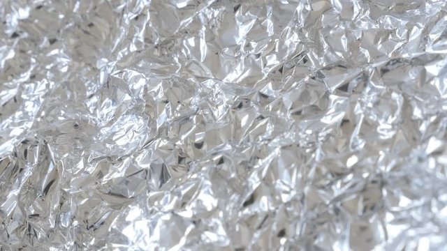 Food protection aluminium foil shiny texture slow tilt 4K 2160p 30fps UltraHD footage - Wrapping metal tin leaves for packing of goods 3840X2160 UHD tilting video 