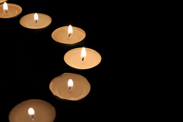 Small candles in the dark in the shape of semicircle