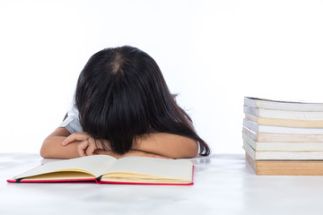 Tired Asian Chinese little girl lying on desk with books