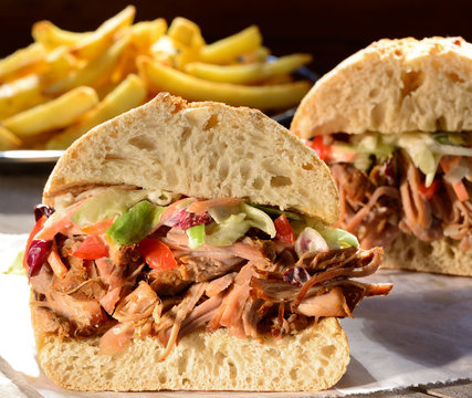 Pulled pork sandwich with coleslaw salad and fries.
