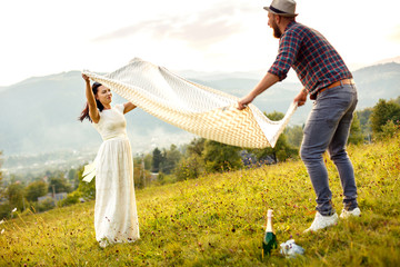 couple in love preparing for picnic. spread white plaid.